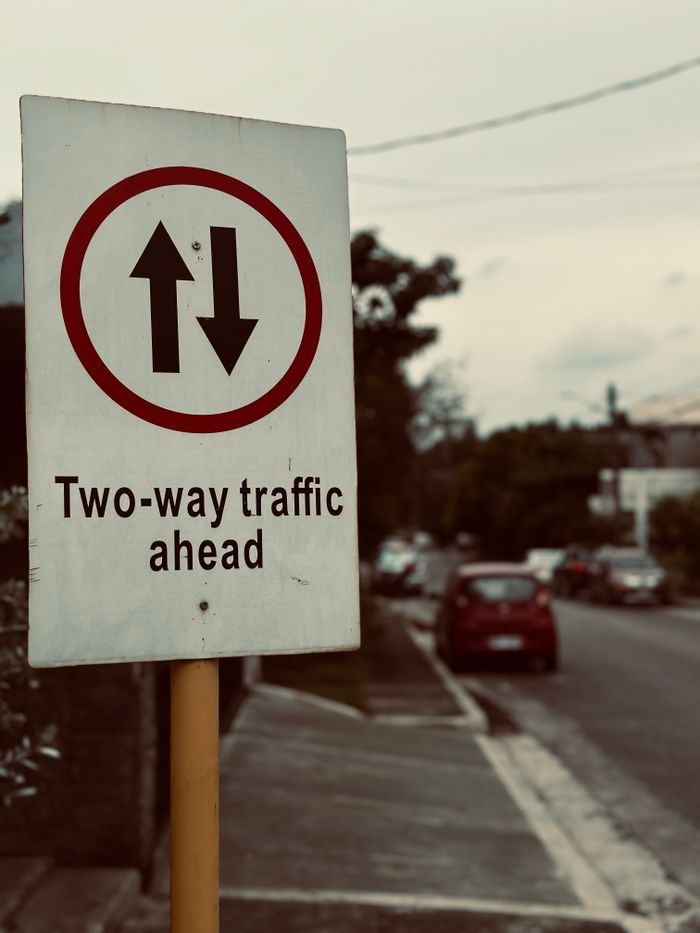 The Art of Drawing Readers In: Your attractive post title goes here A two-way traffic sign on a quiet suburban street, indicating caution ahead.